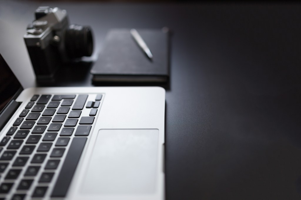 Picture of: Grayscale Photography of Laptop Computer Beside Book and Camera